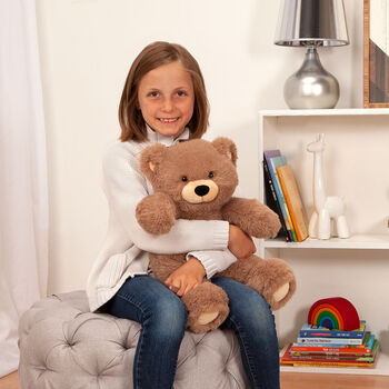 8" Oh So Soft Teddy Bear - Front view of seated honey brown bear in a bedroom scene being held by a girl